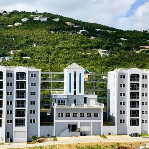 Magens Junction Apartments exterior front of building, with a large hill in the backdrop.