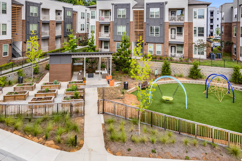 Columbia Residential's Gardenside at the Villages of East Lake -- three-story apartments behind a playground and community garden.