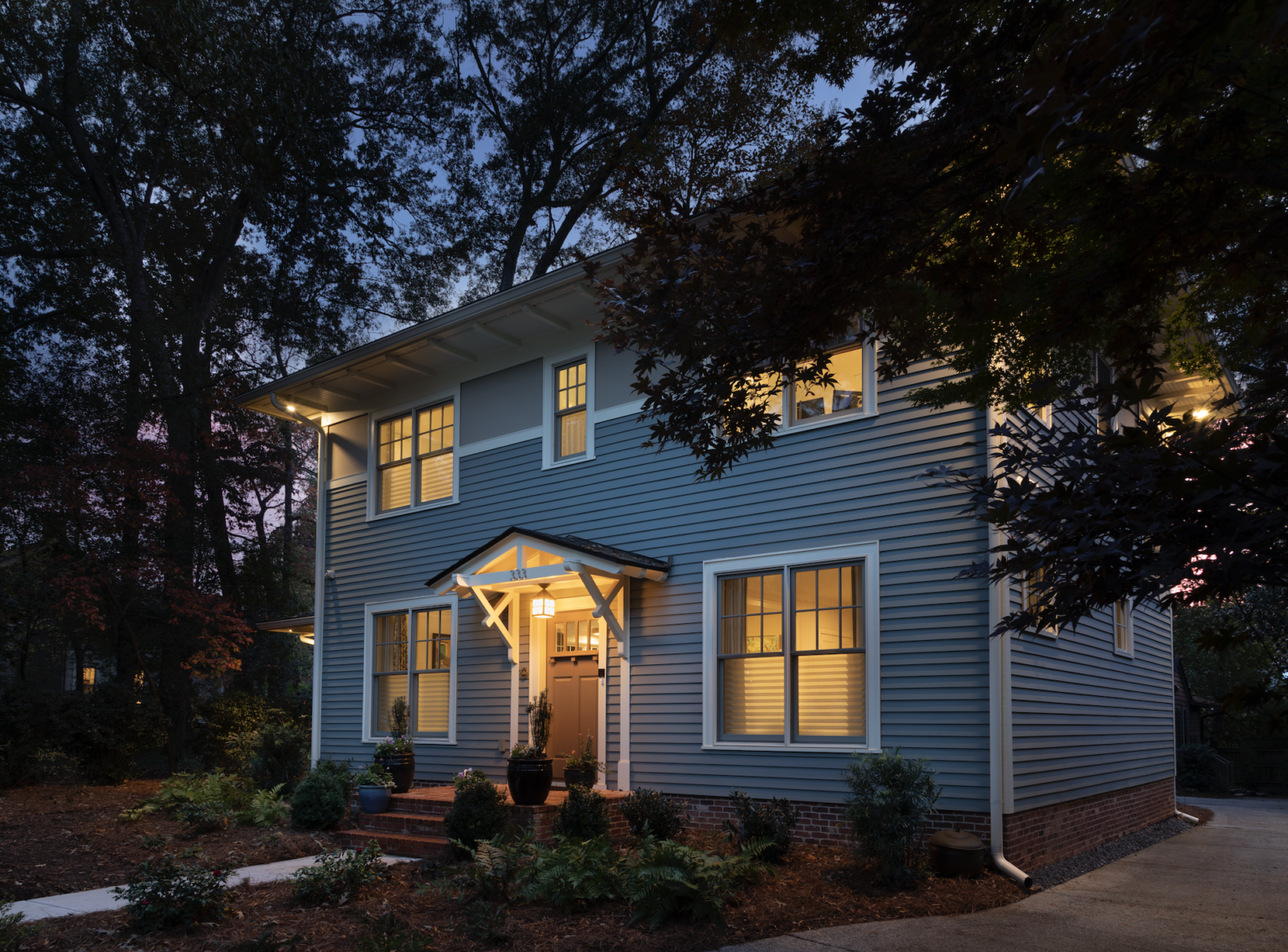 Green certified residence in Decatur, Georgia. A LEED Platinum and NGBS Emerald certified single family home featuring native landscaping. Front of house, view from street at night time.