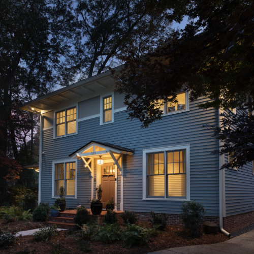 Green certified residence in Decatur, Georgia. A LEED Platinum and NGBS Emerald certified single family home featuring native landscaping. Front of house, view from street at night time.